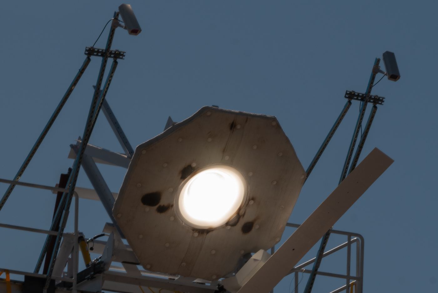 A solar receiver glowing white-hot under concentrated sunlight at the top of a tower